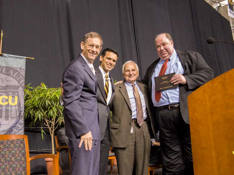 Jurgen Venitz, right, accepts the university's Distinguished Teaching Award on stage at VCU Faculty Convocation in 2013.
