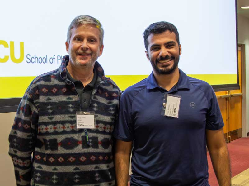 Student award winner Yasir Alshehry stands next to his advisor, past chair Doug Sweet, Ph.D., in front of a lecture hall on Research Day.