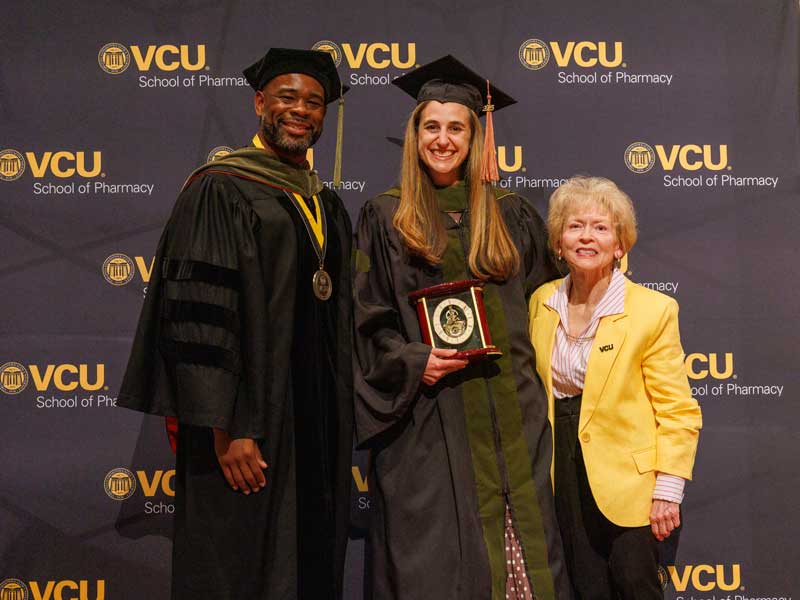 Nicole Omecene in faculty regalia accepts the Lawrence Earle Clevinger Preceptor of the Year Award from Donna Clevinger, Ph.D.