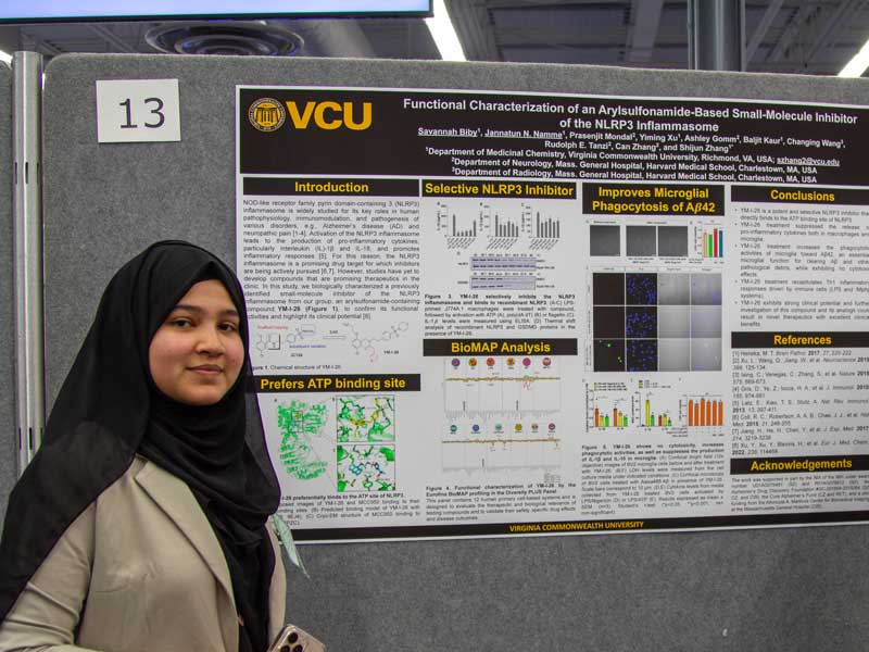 Jannatun Namme stands next to a research poster she shared at Research Day 2024