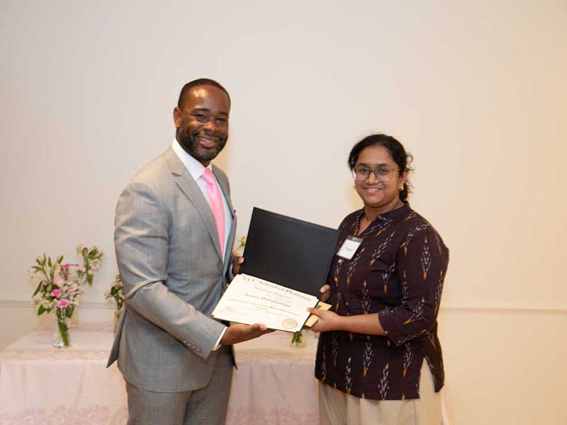 Rasajna Madhusudhana accepts an award from Dean K.C. Ogbonna during the school's Graduate Awards Ceremony