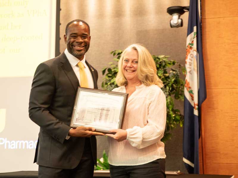 Standing next to Dean K.C. Ogbonna, Sharon Gatewood accepts the Excellence in Service Award